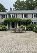 Herringbone brick patio - farmhouse home with summer evening light