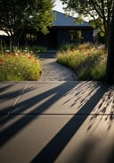 Charcoal raw poured concrete covered entry porch, dark timber board-clad home, late afternoon shadows