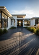 Charcoal polished poured concrete patio, cantilevered flat-roof bungalow, late afternoon diagonal shadows