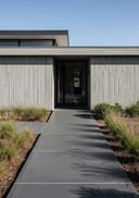 Charcoal polished poured concrete front path, board-formed minimalist home, 3/4 angle, midday