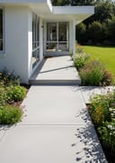 Light grey smooth raw pour poured concrete covered entry porch, single-storey white render home with a flat roof,, bright sunny afternoon, crisp hard shado