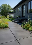 Charcoal broom finish poured concrete open front stoop, dark grey fibre cement bungalow, black window fram, bright sunny midday, high sun, hard cris